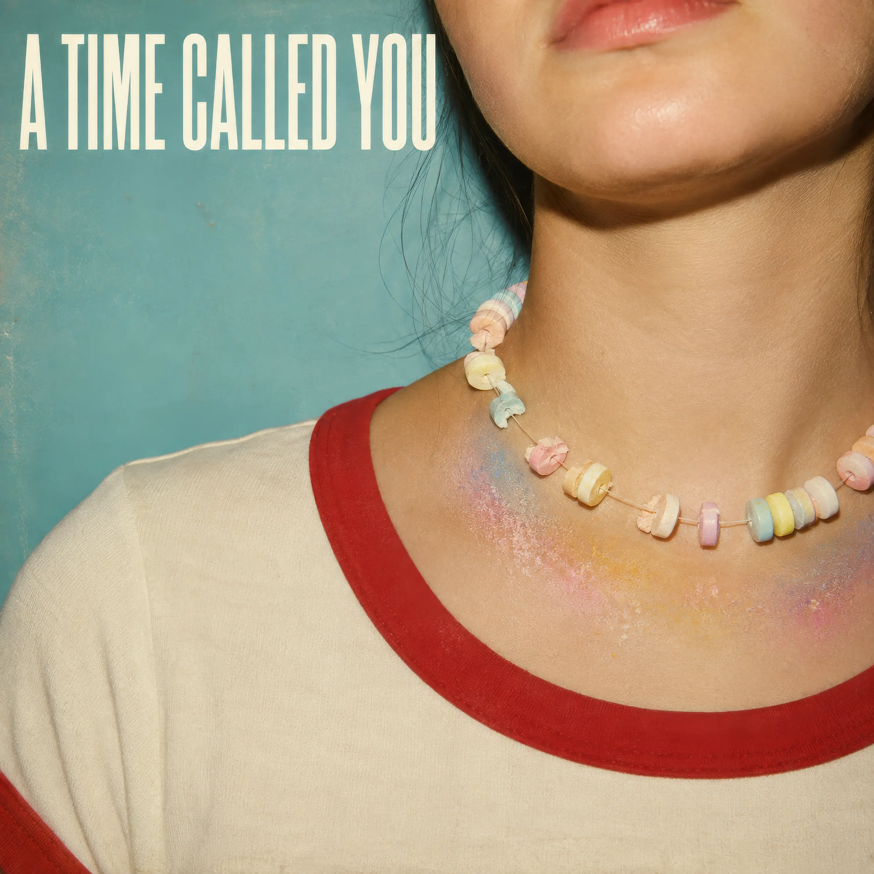 Retro cover for A Time Called You showing a close-up of a young woman wearing a partially eaten candy necklace with pastel candy stains on her neck.